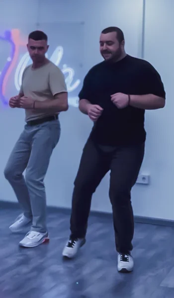 Два чоловіки танцюють Bachata Men Style на занятті в Ola Dance Studio Київ, демонструючи чоловічу техніку та footwork